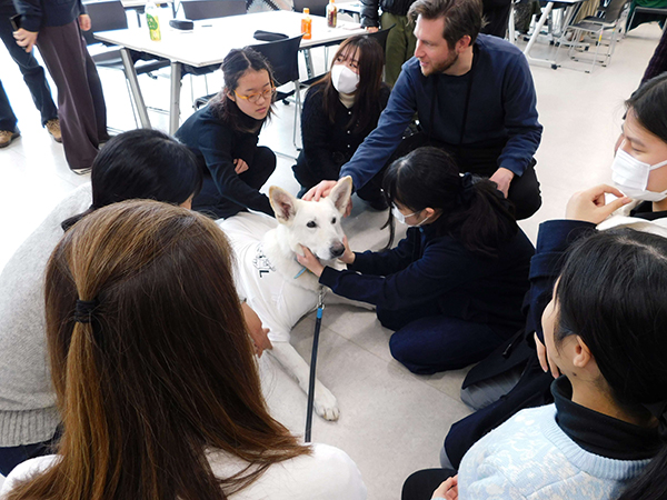 文京女子_2025年の活動の一コマ。両校の生徒と盲導犬がふれ合う様